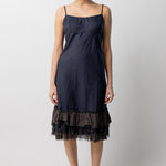 Front view of midnight slip with ruffles on model wearing natural sandals, against a white background.