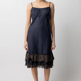 Front view of midnight slip with ruffles on model wearing natural sandals, against a white background.