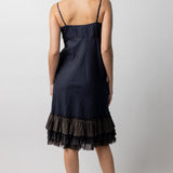 Back view of midnight slip with ruffles on model wearing natural sandals, against a white background.