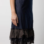 Side closeup view of midnight slip with ruffles on model, against a white background.