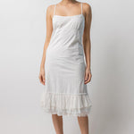 Front view of rice slip with ruffles on model wearing natural sandals, against a white background.