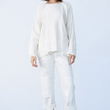 Front view of rice tunisian top on model wearing rice pants and natural sandals, against a white background.