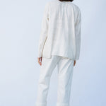 Back view of rice tunisian top on model wearing rice pants and natural sandals, against a white background.