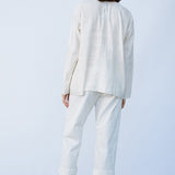 Back view of rice tunisian top on model wearing rice pants and natural sandals, against a white background.