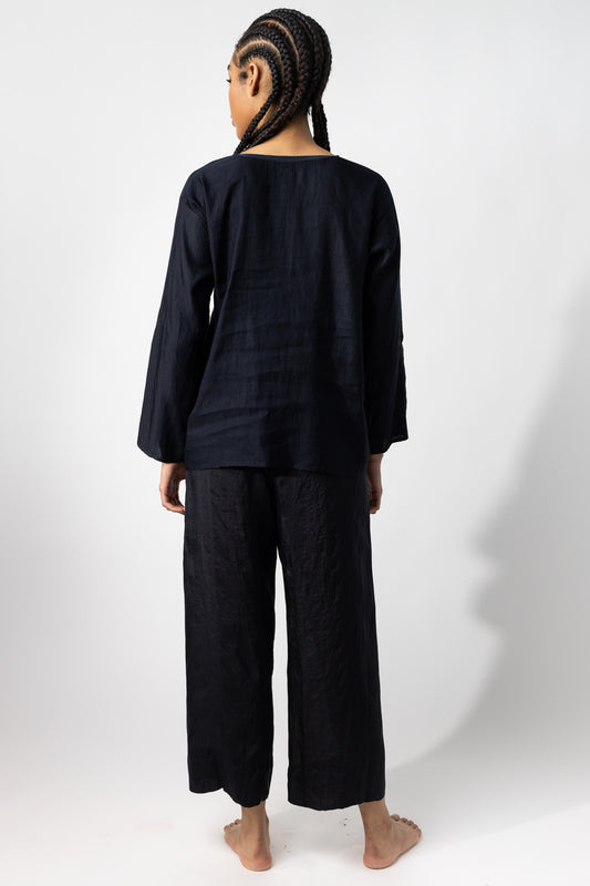 Back view of midnight tunisian top on model wearing midnight pants, against a white background.