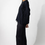 Side view of midnight tunisian top on model wearing midnight pants, against a white background.