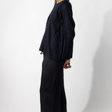 Side view of midnight tunisian top on model wearing midnight pants, against a white background.