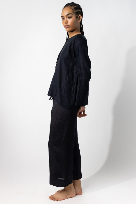 Side view of midnight tunisian top on model wearing midnight pants, against a white background.