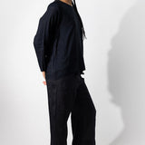Alternate side view of midnight tunisian top on model wearing midnight pants, against a white background.