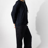 Side view of midnight wide leg pants on model wearing midnight top, against a white background.