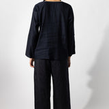 Back view of midnight wide leg pants on model wearing midnight top, against a white background.