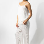 Side view of rice wide leg pants on model wearing rice top and natural sandals, against a white background.