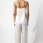 Back view of rice wide leg pants on model wearing rice top and natural sandals, against a white background.