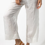 Front closeup view of rice wide leg pants on model wearing rice top and natural sandals, against a white background.
