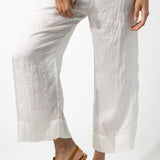 Front closeup view of rice wide leg pants on model wearing rice top and natural sandals, against a white background.