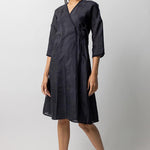 Front view of midnight wrap dress on model wearing natural sandals, against a white background.