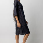 Side view of midnight wrap dress on model wearing natural sandals, against a white background.