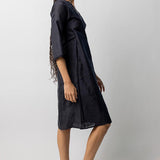 Side view of midnight wrap dress on model wearing natural sandals, against a white background.