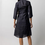 Back view of midnight wrap dress on model wearing natural sandals, against a white background.