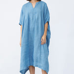Front view of denim yoruba tunic on model wearing leather sandals, against a white background.