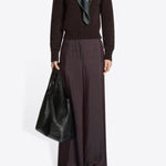Front view of burgundy penn wide leg pant on model wearing brown sweater, and floral scarf against a white background.