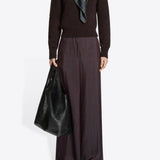Front view of burgundy penn wide leg pant on model wearing brown sweater, and floral scarf against a white background.