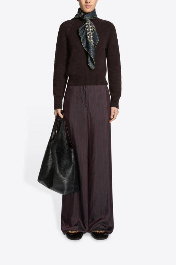 Front view of burgundy penn wide leg pant on model wearing brown sweater, and floral scarf against a white background.