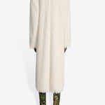 Back view of white Rivla Fringed Coat on model wearing green print boots against a white background.