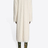 Back view of white Rivla Fringed Coat on model wearing green print boots against a white background.
