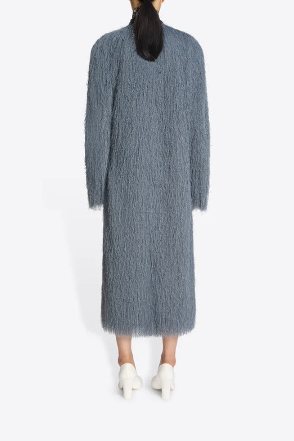 Back view of dark grey Rivla Fringed Coat on model wearing white heels, against a white background.
