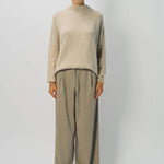 Front view of vanilla cashmere cn kimono sleeve sweater on model wearing sand pants, against a white background.