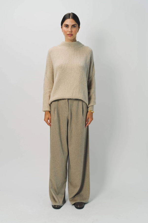 Front view of vanilla cashmere cn kimono sleeve sweater on model wearing sand pants, against a white background.