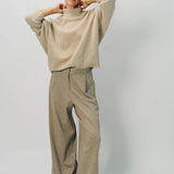 Alternate front view of vanilla cashmere cn kimono sleeve sweater on model wearing sand pants, against a white background.