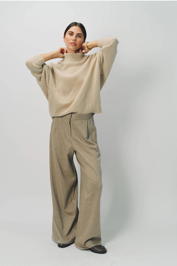Alternate front view of vanilla cashmere cn kimono sleeve sweater on model wearing sand pants, against a white background.