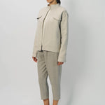Front slanted view of oatmeal cashmere double face jean jacket on model wearing stone pants, against a white background.