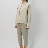 Front slanted view of oatmeal cashmere double face jean jacket on model wearing stone pants, against a white background.