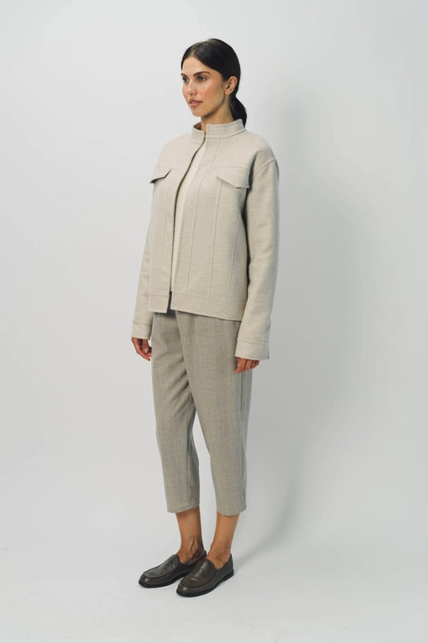 Front slanted view of oatmeal cashmere double face jean jacket on model wearing stone pants, against a white background.