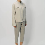 Alternate front slanted view of oatmeal cashmere double face jean jacket on model wearing stone pants, against a white background.