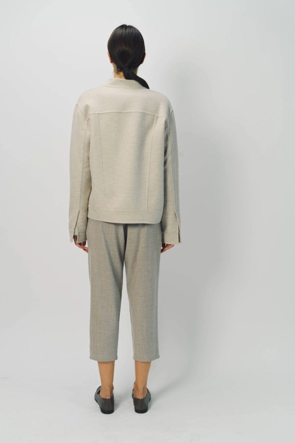 Back view of oatmeal cashmere double face jean jacket on model wearing stone pants, against a white background.