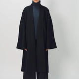 Front view of midnight long kimono coat on model wearing navy turtleneck and navy pants, against a white background.