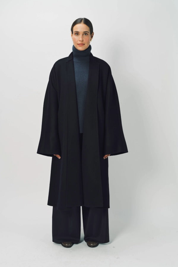 Front view of midnight long kimono coat on model wearing navy turtleneck and navy pants, against a white background.