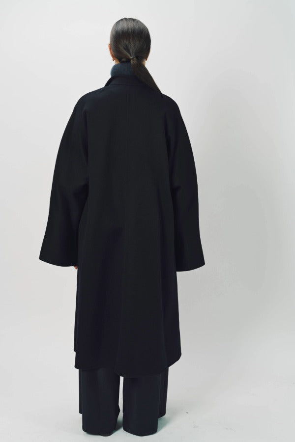 Back view of midnight long kimono coat on model wearing navy pants, against a white background.