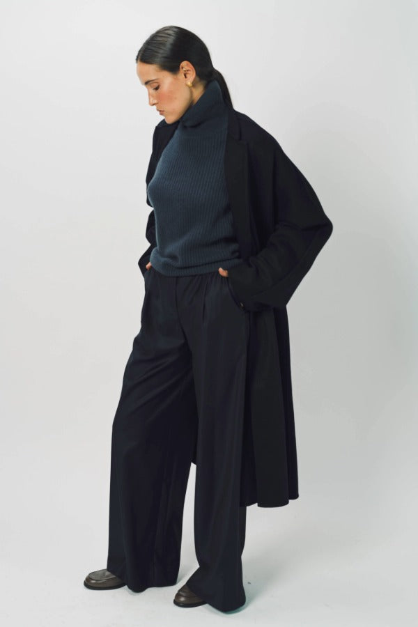 Front slanted view of midnight long kimono coat on model wearing navy turtleneck and pants, against a white background.