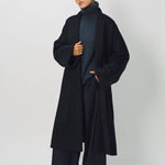 Alternate front view of midnight long kimono coat on model wearing navy turtleneck and pants, against a white background.