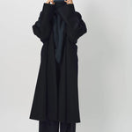 Alternate front view of midnight long kimono coat on model wearing navy turtleneck and pants, against a white background.