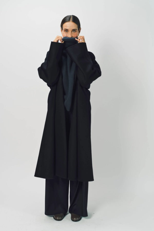Alternate front view of midnight long kimono coat on model wearing navy turtleneck and pants, against a white background.