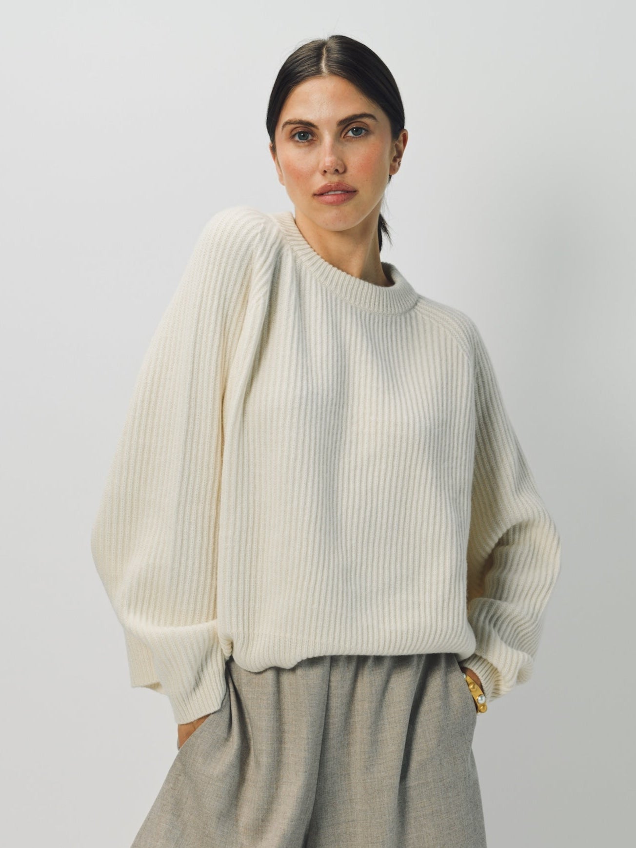 Front view of bone ls crew neck sweater on model wearing grey pants, against a white background.  