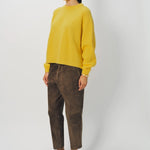 Side view of sunray ls crew neck sweater on model wearing brown pants and loafers, against a white background.