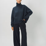 Front view of midnight ls t-neck raglan sweater on model wearing navy pants, against a white background.