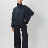 Front view of midnight ls t-neck raglan sweater on model wearing navy pants, against a white background.